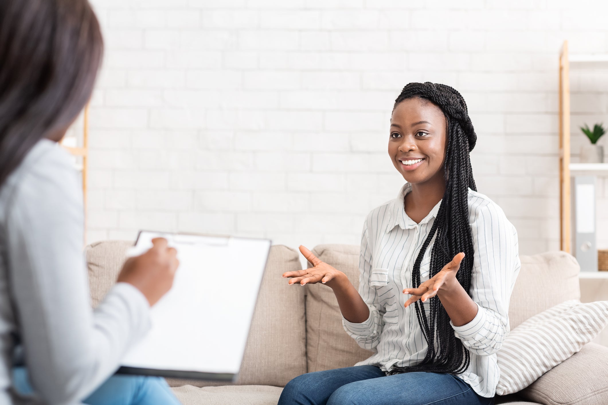 Two women in a therapy session in a home setting.